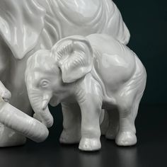 two white ceramic elephants standing next to each other