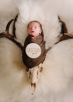 a newborn baby is wrapped in a deer's antlers blanket with the name easton printed on it