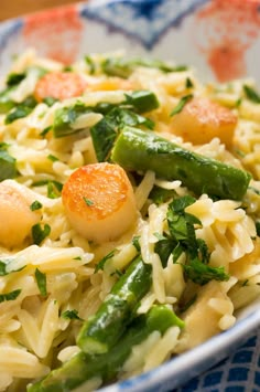 pasta with asparagus, carrots and parmesan cheese in a bowl