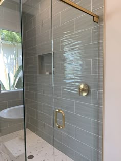 a walk in shower sitting next to a white bath tub under a bathroom window with glass doors