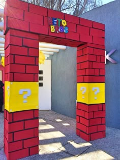 a red and yellow building with question marks on it's front door that is made out of cardboard