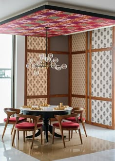 a dining room table with chairs and a chandelier hanging from it's ceiling