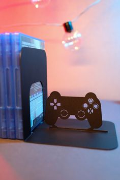 a video game controller next to a stack of blue pens on top of a table