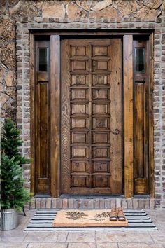 a wooden door sitting on the side of a stone building next to a potted plant