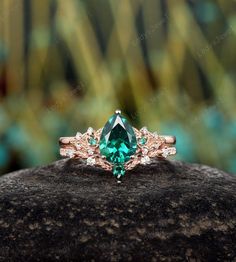 an emerald colored ring on top of a rock