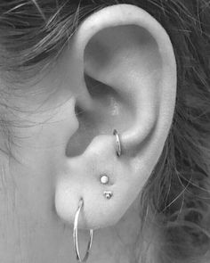 a close up of a person's ear with two piercings