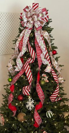 a decorated christmas tree with red and white ribbons