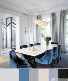 an elegant dining room with blue chairs and chandelier