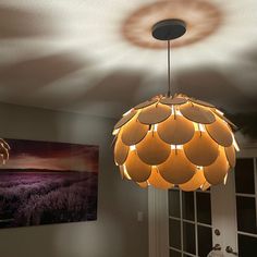 a chandelier hanging from the ceiling in a room with two pictures on the wall