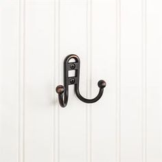 an iron hook on the side of a white door