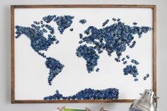 a blue and white world map made out of puzzles on a wall next to a lamp