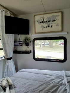 a bedroom with a bed, window and curtains in front of the tv on the wall