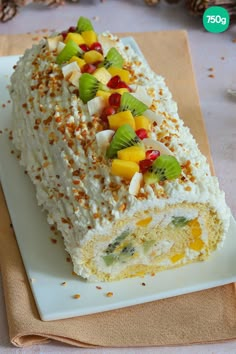 a piece of cake with fruit on top is sitting on a plate next to a napkin