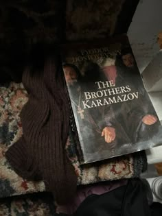 the brothers karamazo book laying on top of a pile of clothes