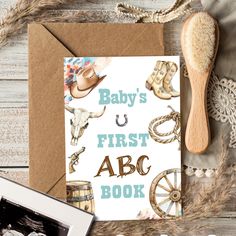 a baby's first abc book next to an old fashioned wooden spoon and other items