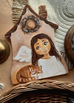 a painting of a girl holding a cat on top of a table next to a clock