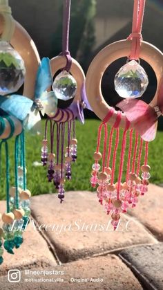 three wind chimes are hanging on the grass