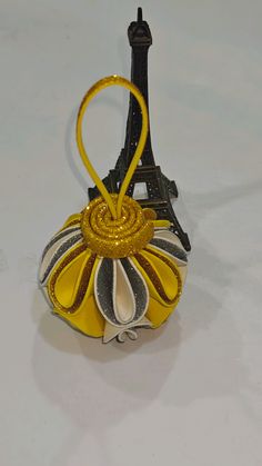 an ornament shaped like the eiffel tower in yellow and black colors