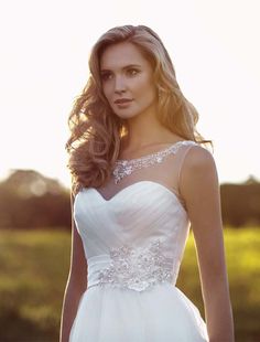 a woman in a white wedding dress posing for the camera with her hand on her hip