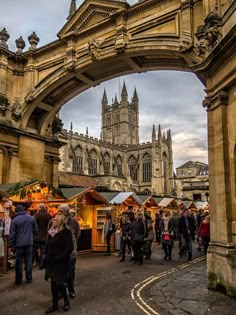 people are walking under an archway at the christmas market