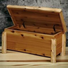 a wooden box sitting on top of a wooden table next to a wall and floor