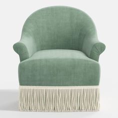 a green chair with fringe trim around the legs