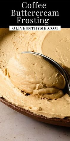 a spoon full of coffee butter sitting on top of a bowl filled with frosting