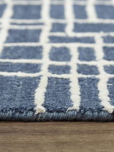 a blue and white area rug on a wooden floor with a wood floor in the background