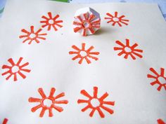 an orange and white piece of paper with snowflakes on it next to some scissors