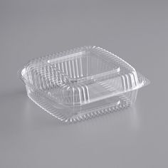 two clear plastic containers on a gray surface