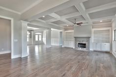 an empty living room with wood floors and white walls