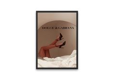 a woman's legs and heels are shown in front of an advertisement for dolce & garbana