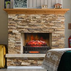 a fire place in a living room with a blanket on the floor and blankets around it