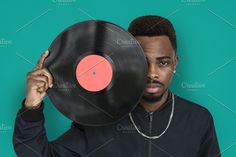 a man holding up a record in front of his face