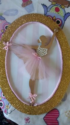 a ballerina ornament in pink and gold on a tablecloth with an owl background