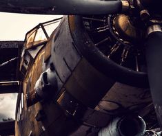 an old airplane is sitting on the ground next to some metal pipes and pipework