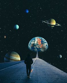 a person walking down a road surrounded by planets