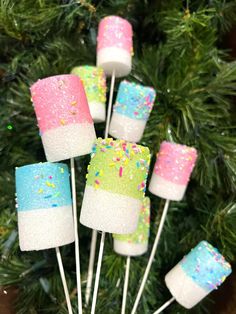 marshmallow pops on a stick with sprinkles and colored frosting