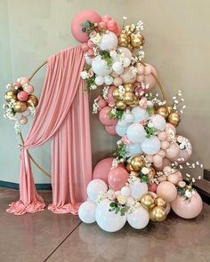 a balloon arch with balloons and flowers on it