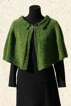 a green jacket on top of a black dress