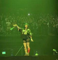 a woman standing on top of a stage in front of a crowd