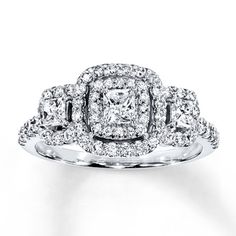 an engagement ring with three square cut diamonds on the sides and two round brilliant pave set shoulders