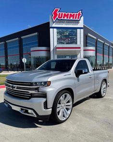 a silver truck parked in front of a building