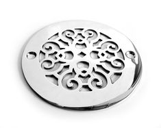 a round metal object with an intricate design on the center and sides, sitting on a white surface