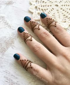 two fingers with henna tattoos on them