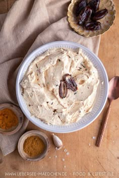 a bowl filled with hummus next to bowls of spices