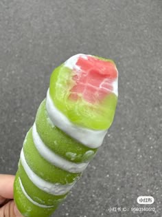 a person holding up a green and white candy