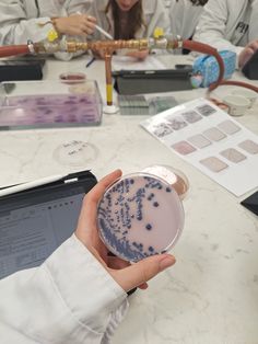 a person holding a plate with blue dots on it in front of other people sitting at a table