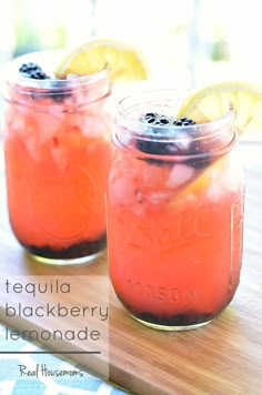 two mason jars filled with lemonade and blackberries