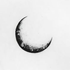 a crescent moon is shown in black and white with water droplets on the surface, against a light gray background